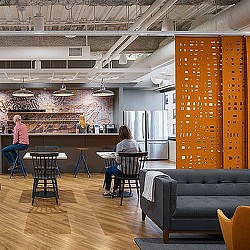 A group of people sitting at a table in a room with a fireplace.