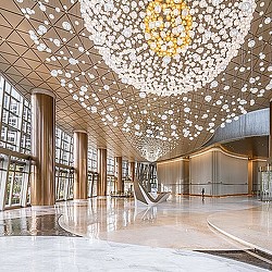 A large library with many bookshelves and a large chandelier.