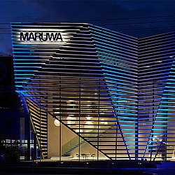 Maruwa R&D Center exterior lit up at night.