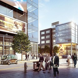 A group of people walking on a sidewalk next to a building.