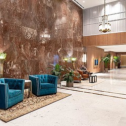 A room with blue couches and a stone wall.