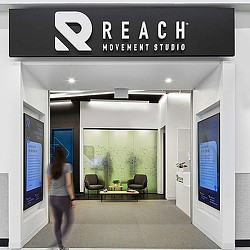 A woman walking into Reach Movement Studio.