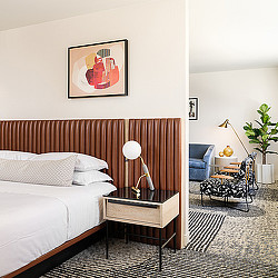 A bedroom with a bed and a chair.