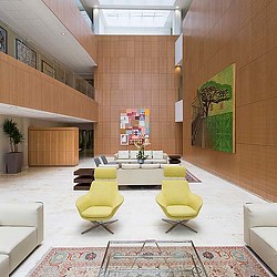 A room with a couch and chairs.