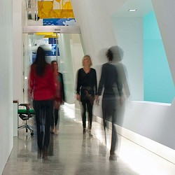 A group of people walking in a hallway.