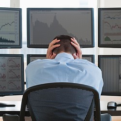 A person sitting in a chair with the hands on the head.