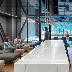 A group of people sitting in a room with a large glass wall.