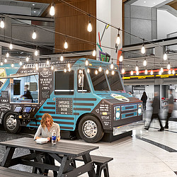 A person sitting at a table in front of a truck.