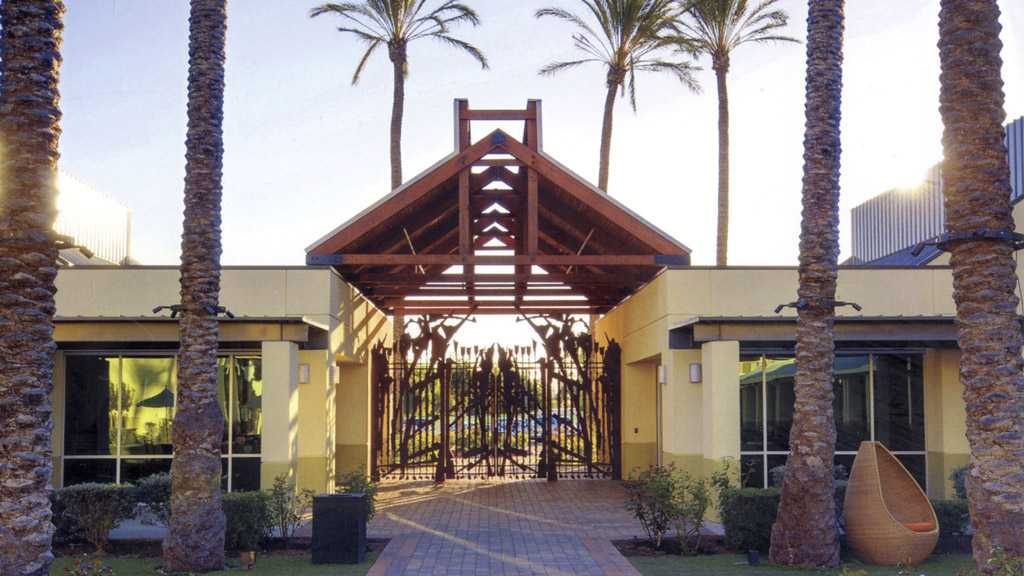 A building with a deck and palm trees.