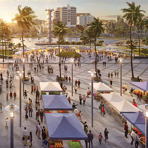A group of people walking around a plaza with tents and trees.
