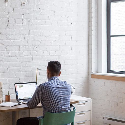 A person sitting at a desk with a laptop.