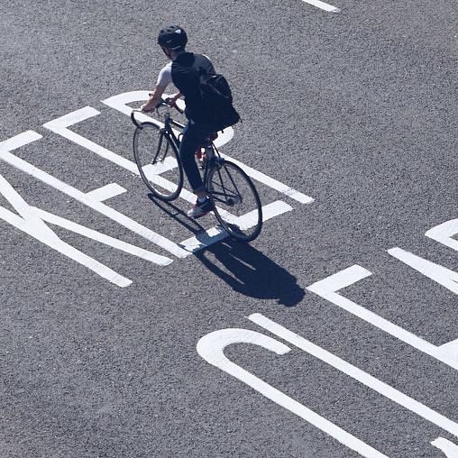 A person riding a bicycle in a crosswalk.