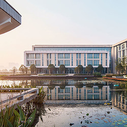 A building with a pond in front.
