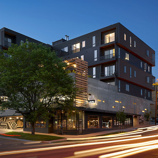 A building with a tree in front.