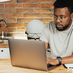 A man sitting at a table with a laptop.