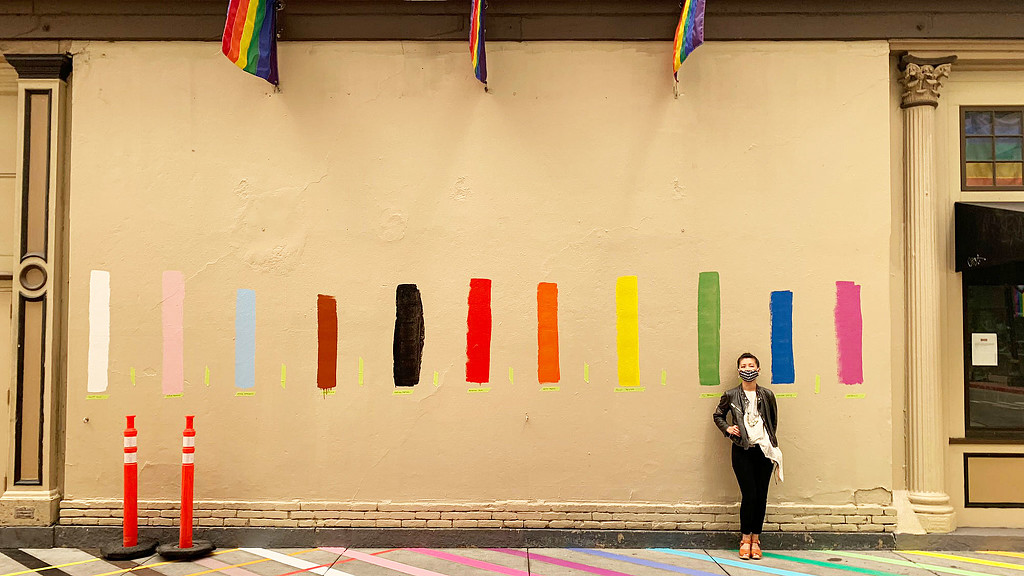 A person standing in front of a wall with flags.