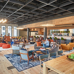 A person sitting in a chair in a room with tables and chairs.