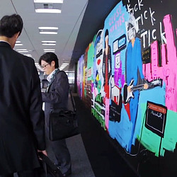 A couple of men looking at a wall of art.