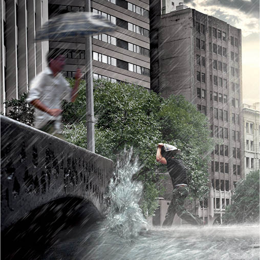 A man holding an umbrella in a downpour in the city.