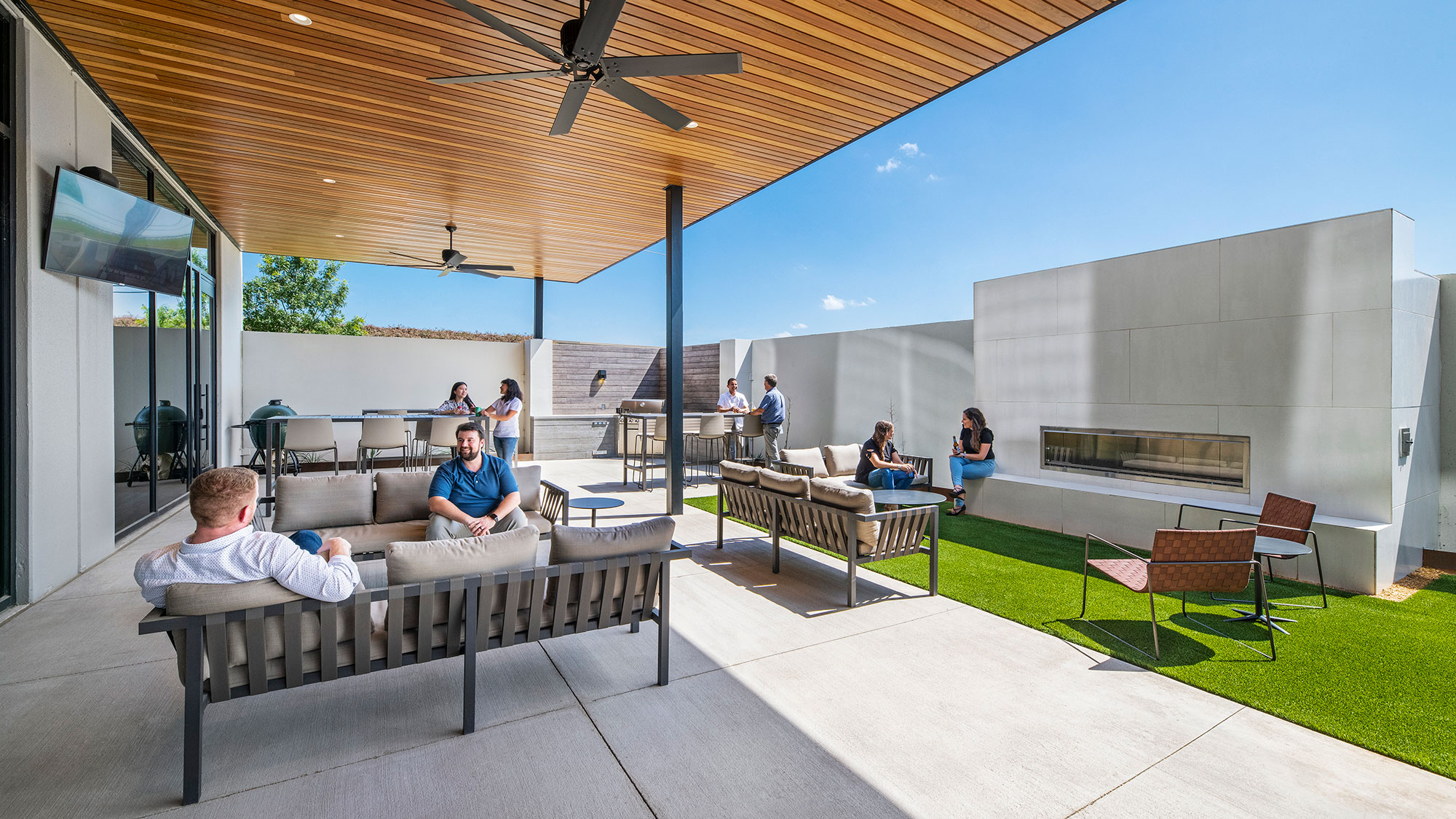 People working and socializing in an outdoor rooftop workspace.