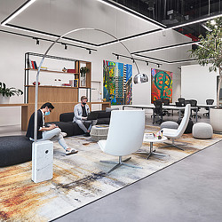 A couple of men sitting on a couch in a room with a glass ceiling and a large glass.