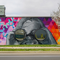 CBI Art Wall public mural of face with 3D binoculars