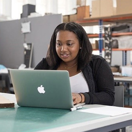 A woman sitting at a table with a laptop.