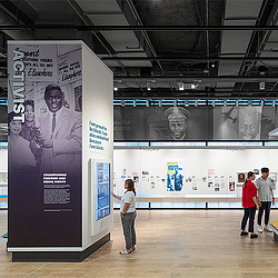 People standing next to a large poster.