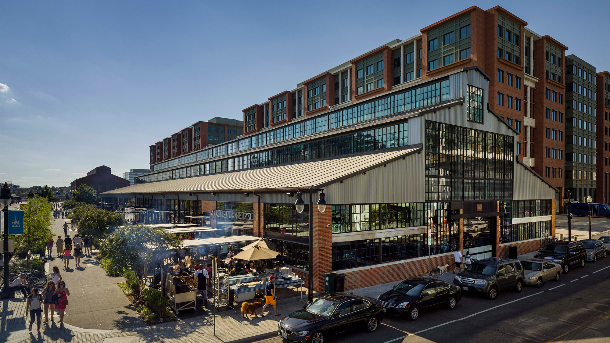 A street with cars and people on it next to a building.