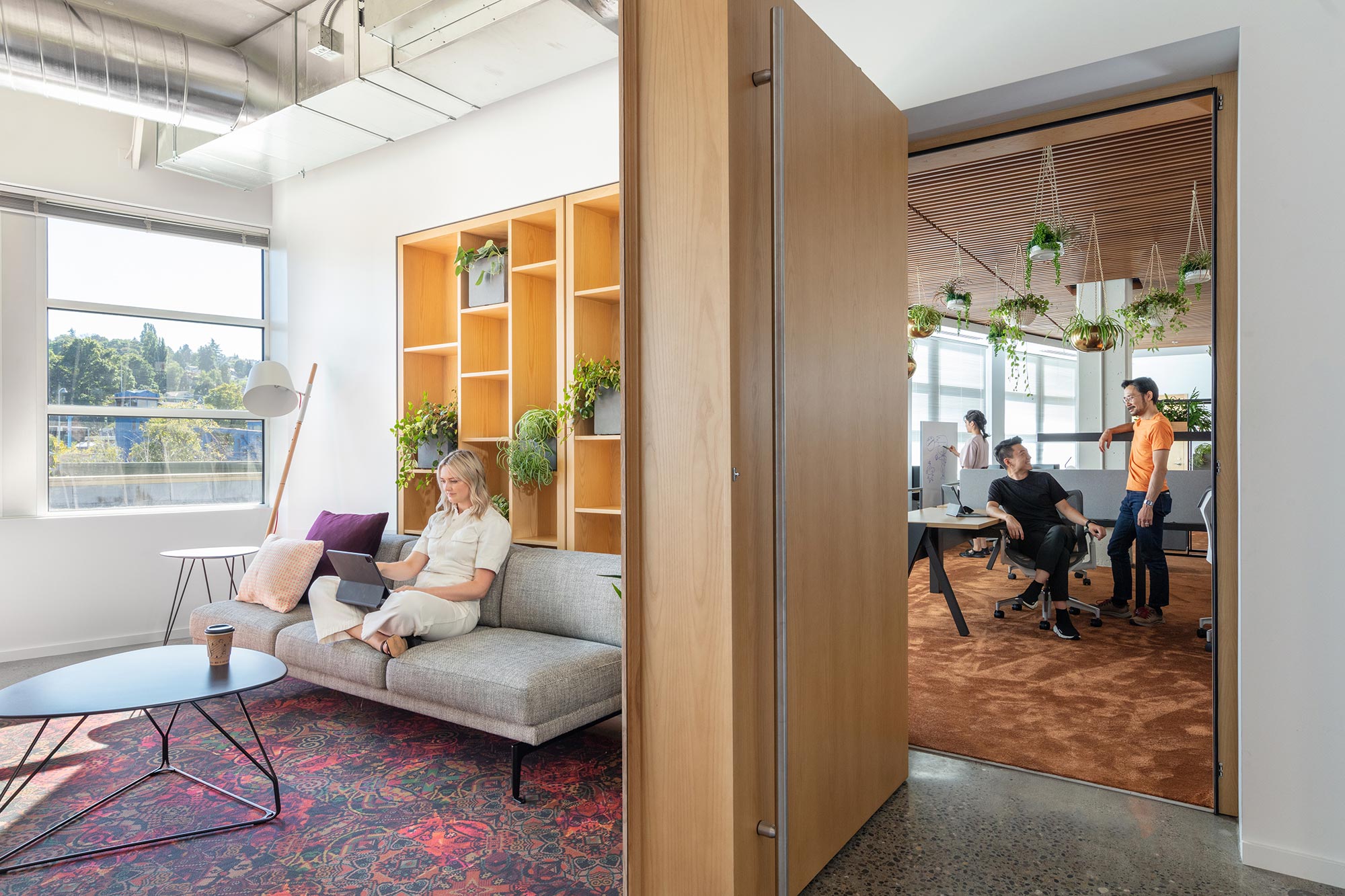 Woman in cozy lounge room at Adobe Seattle with door ajar