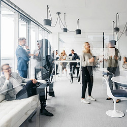 Employees mingling in office. Photo via Getty Images/Washingtonian.