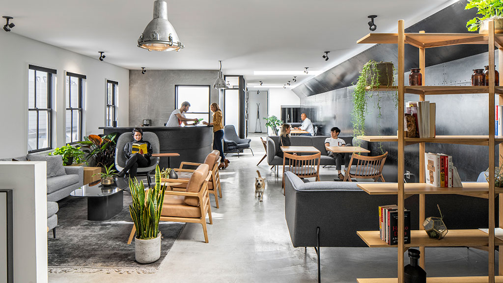 People working in a variety of spaces inside an office.