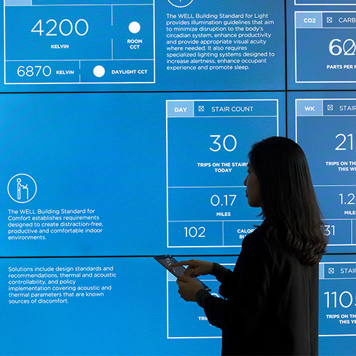 A person standing in front of a large screen.