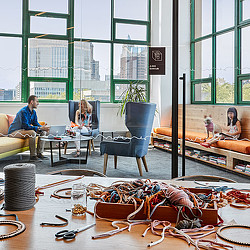 A group of people sitting in a room with a table and chairs.