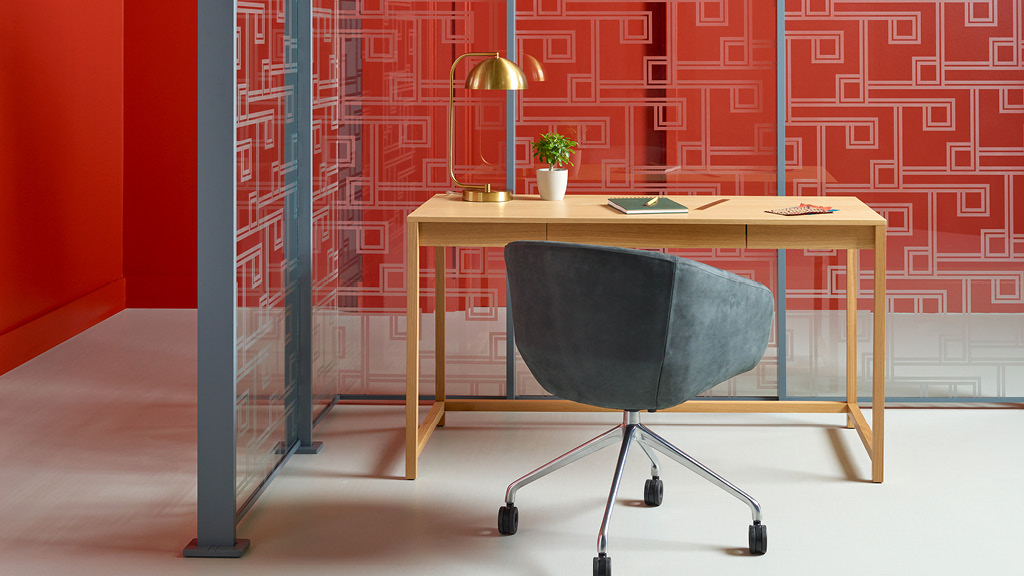 A desk with a chair and a lamp on it.