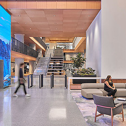 A person sitting on a couch in a room with a staircase.
