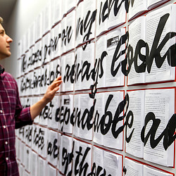A man looking at Chick-fil-A campus book art wall.