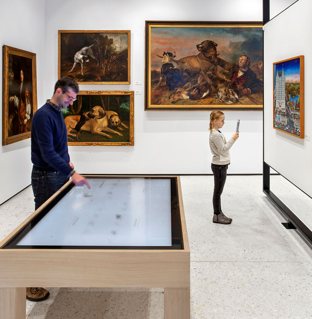A man and a girl looking at art on the wall.