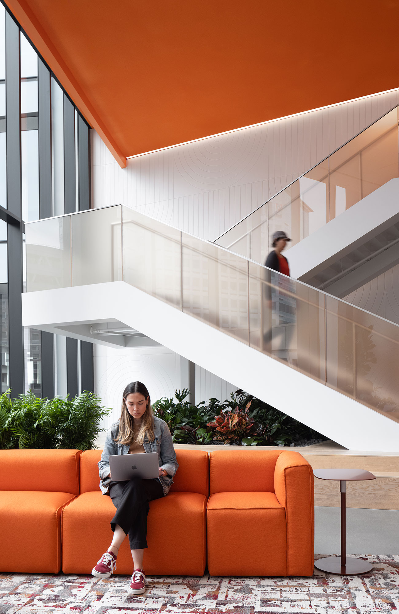 A woman sitting on a couch with a laptop.
