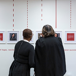 2 women viewing photo wall at Dress for Success Boutique and Career Center.