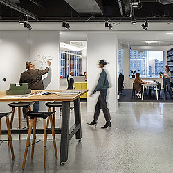 A person standing in front of a table with a laptop on it.