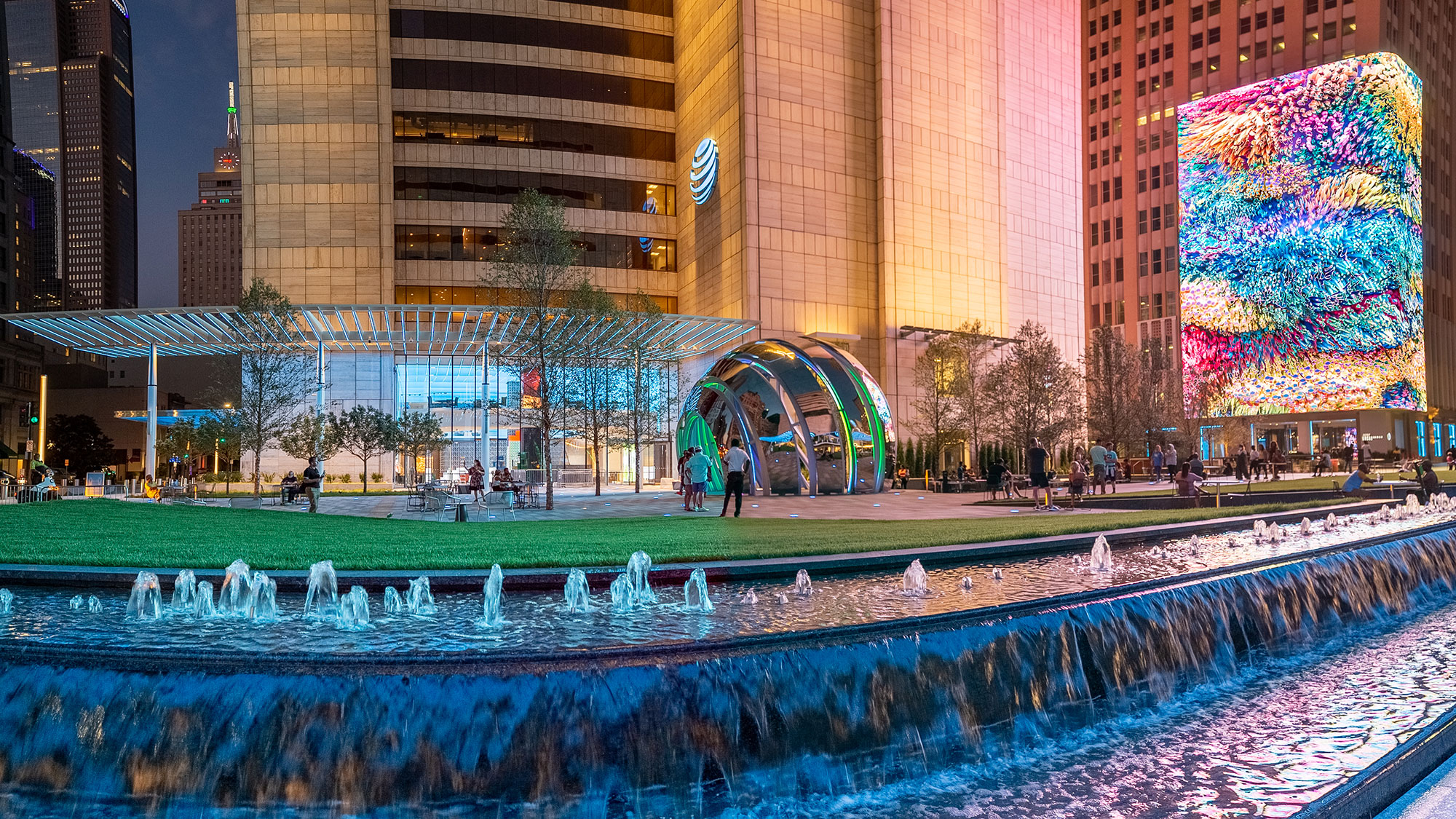 A large water fountain near a digital media wall.