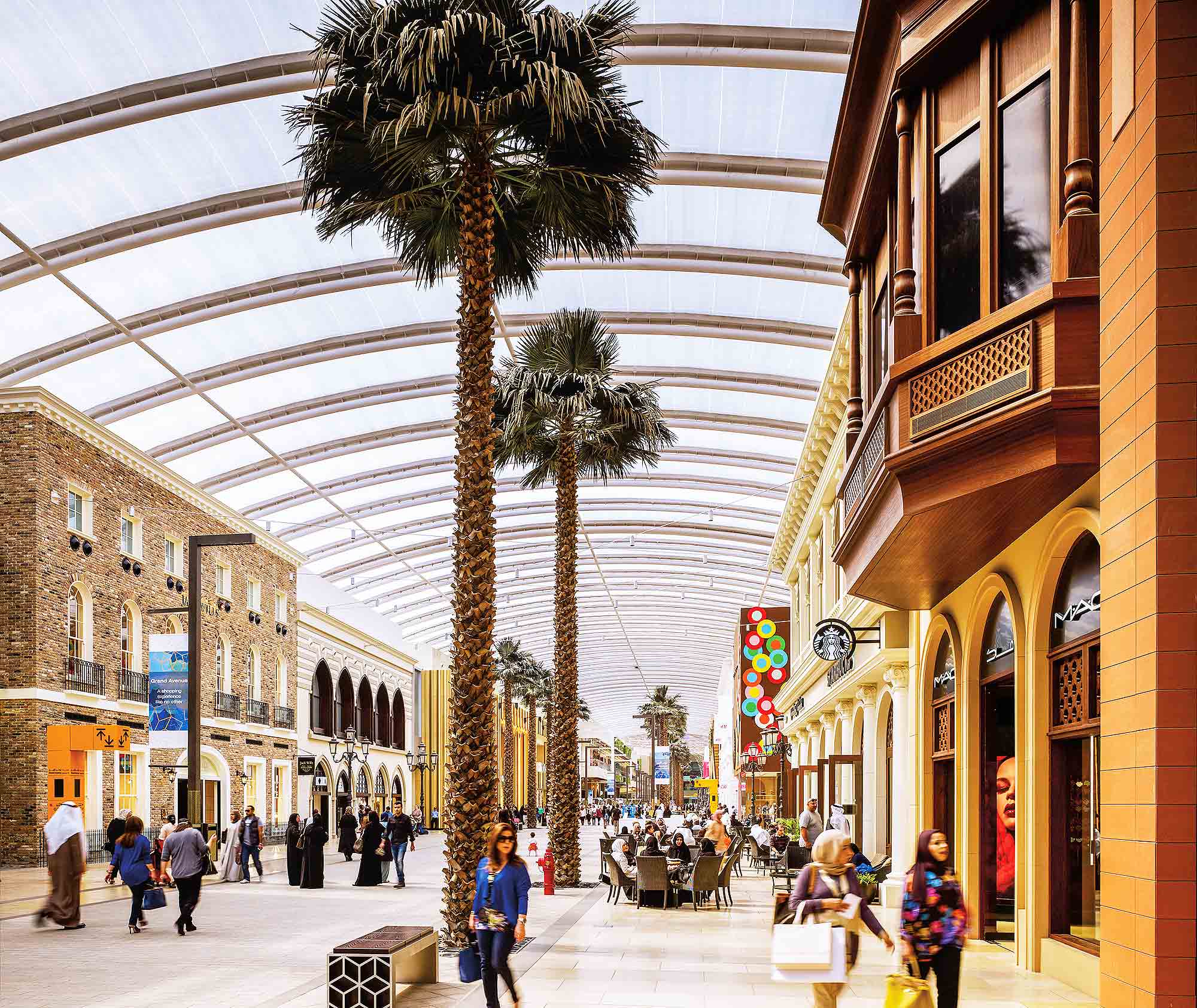 A street with palm trees and people.