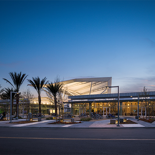 A building with palm trees in front.