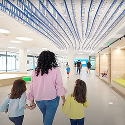 Mother and 2 daughters holding hands walking into Frisco Public Library