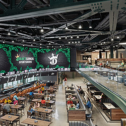 A large sports entertainment venue at DraftKings Sportsbook interior with large screens and a bar