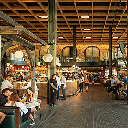 People sitting at tables in a large building.