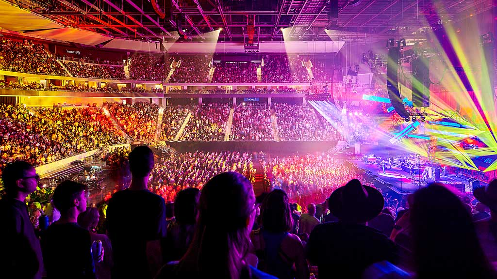 A crowd of people inside the immersive stadium experience at Moody Center.