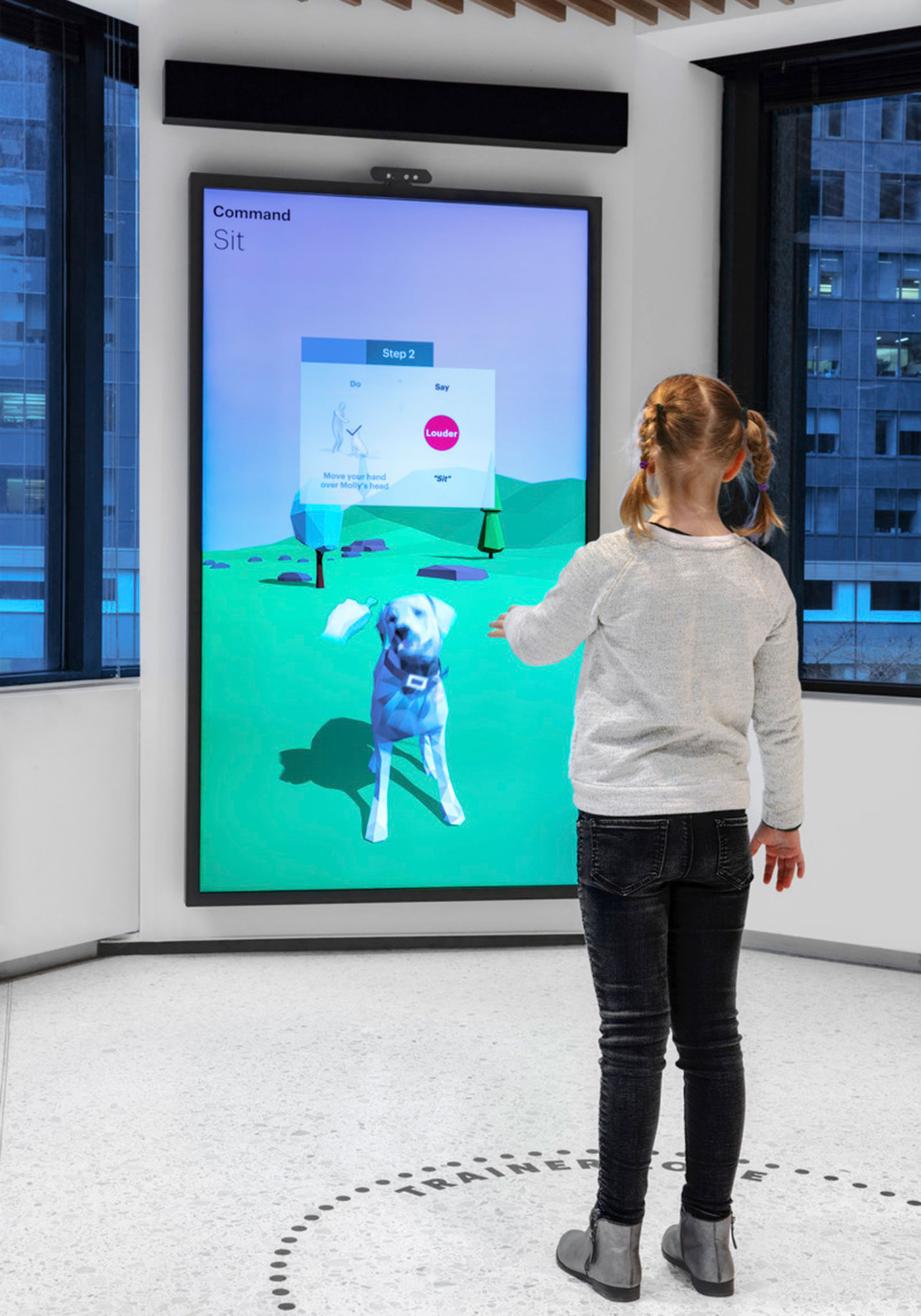 A person standing next to a large screen.
