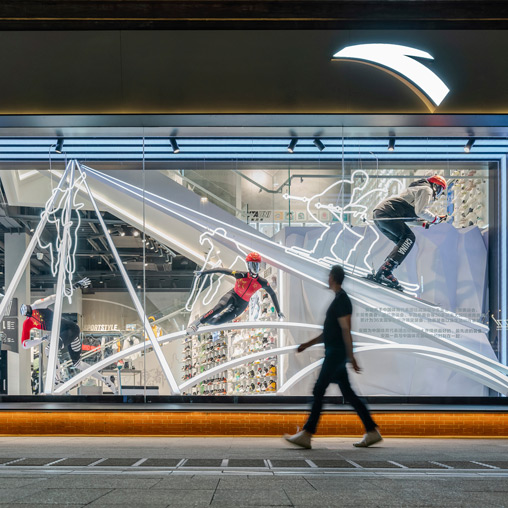 A person walking past a storefront display.